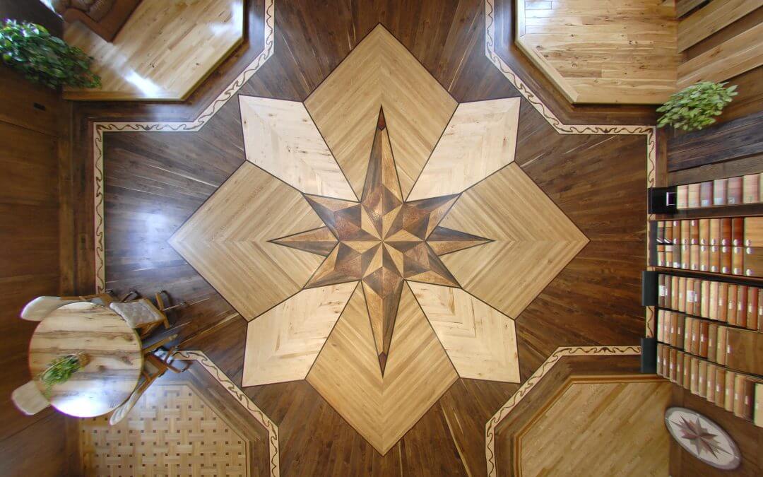 An Ariel view of the Barnum Floors showroom, which features a custom medallion in the middle of the floor made of different hardwoods, along with hardwood samples lining the walls.