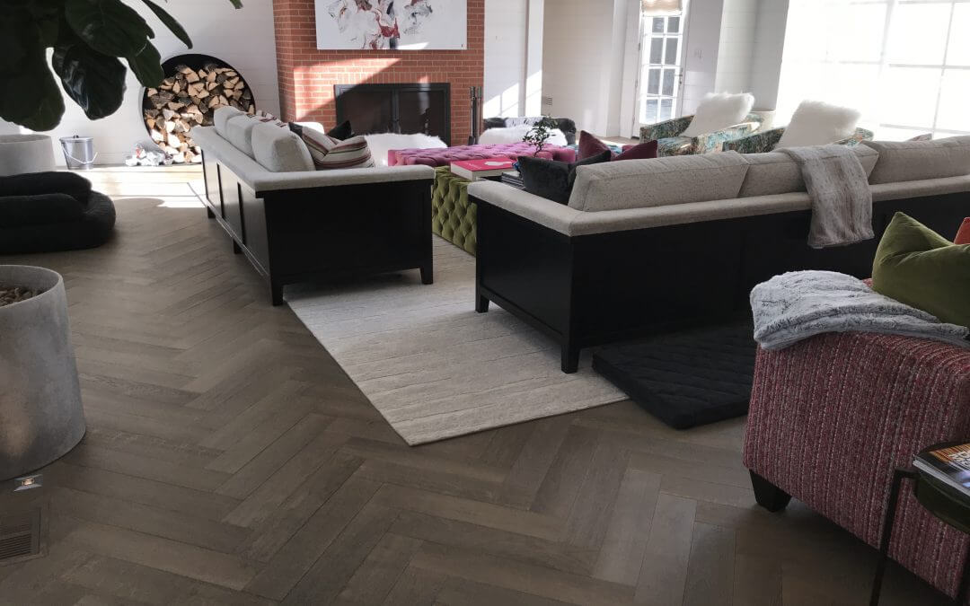 A living room featuring taupe-colored pre-finished hardwood flooring.